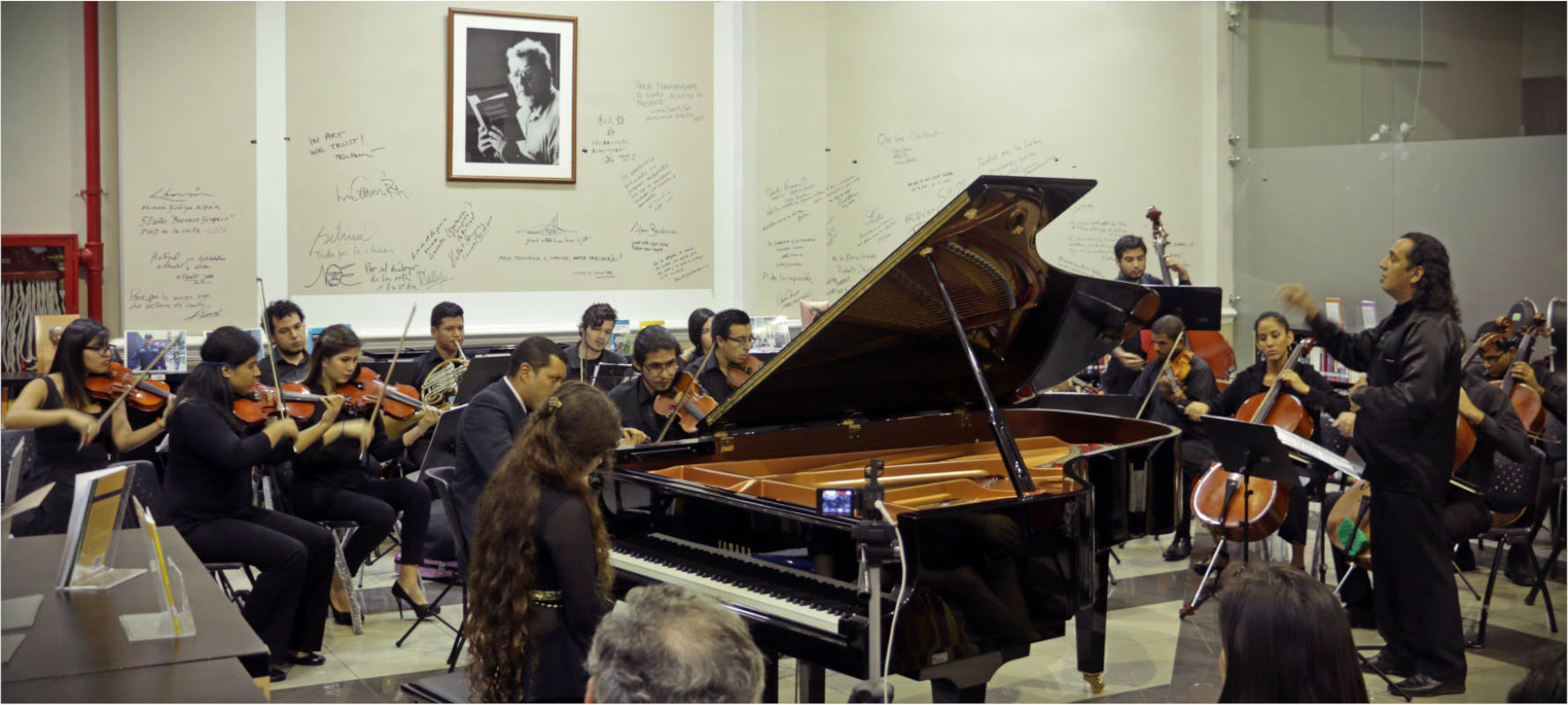 A person conducting a concert for piano and orchestra